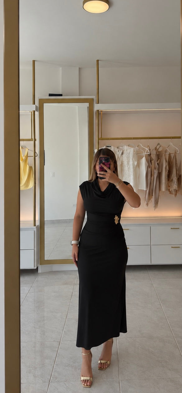 Vestido negro con broche dorado